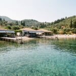 Agni Bay tavernas and jetties Corfu - SeaDreamers Agni Bay on Corfu northeast coast with waterfront tavernas and jetties seen from a boat