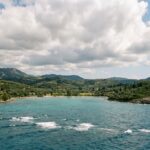 Open Ionian water with light whitecaps and a calm sheltered bay near Corfu