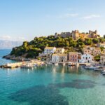 Kassiopi harbour and Byzantine castle on the northeast coast of Corfu, seen from a boat